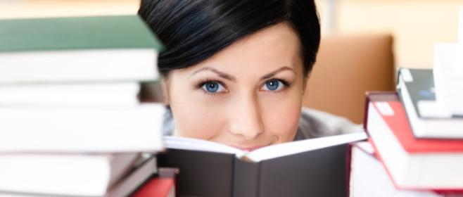 Frau hinter Bücherstapeln