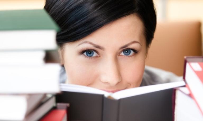 Frau hinter Bücherstapeln