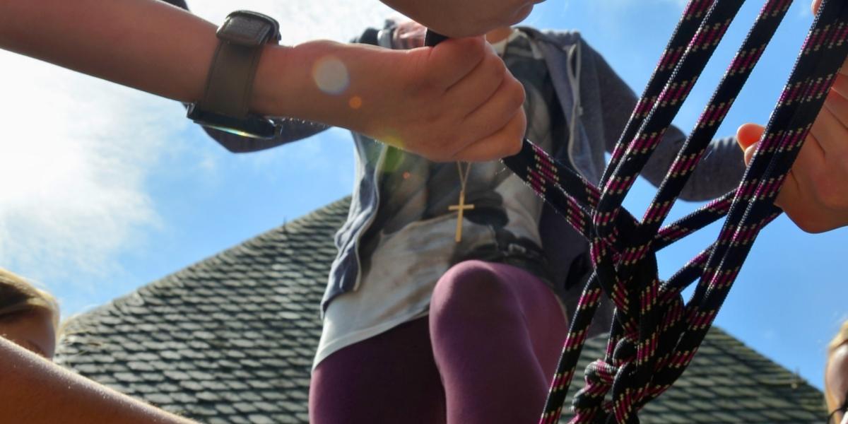 Menschen klettern auf ein Klettergerüst aus Tauen