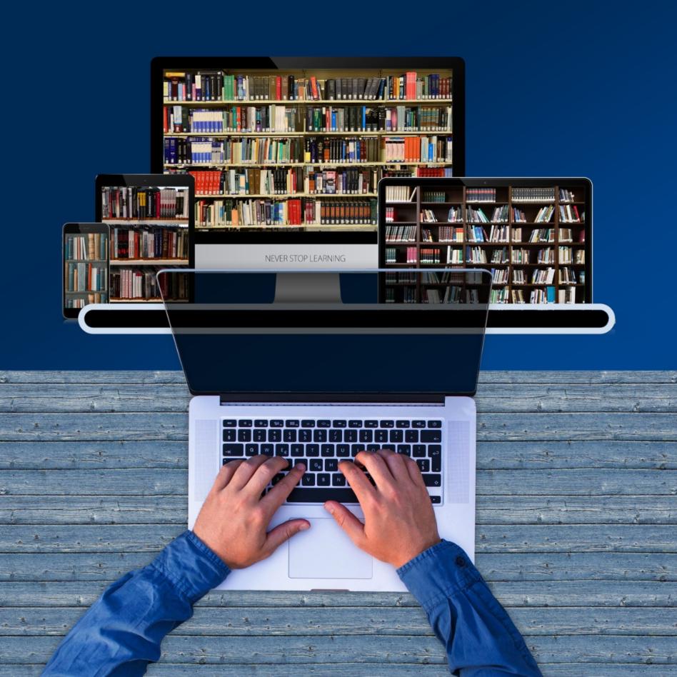 Person schreibt auf der Tastatur auf einem Laptop, im Hintergrund Bücherregal