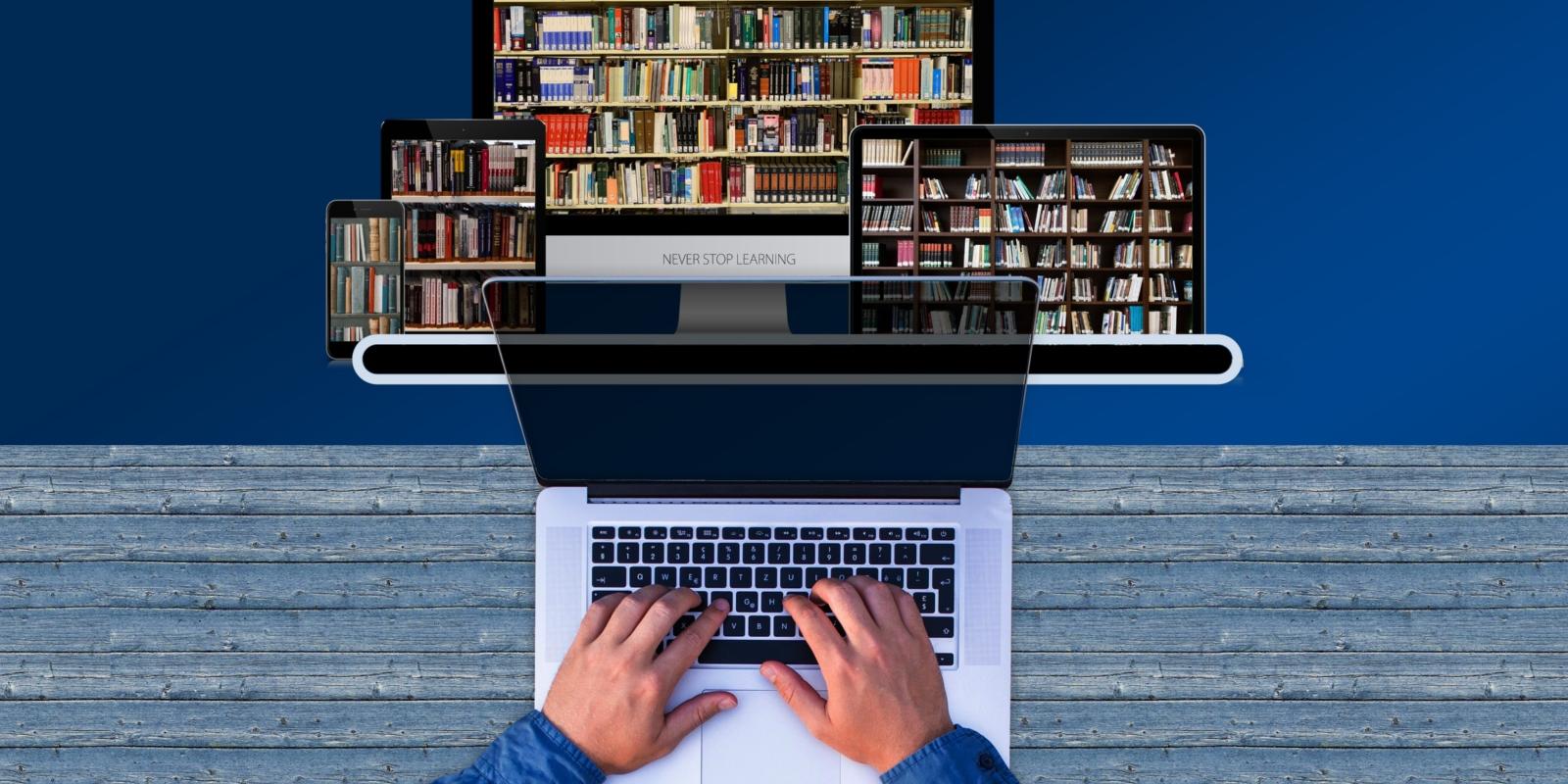 Person schreibt auf der Tastatur auf einem Laptop, im Hintergrund Bücherregal