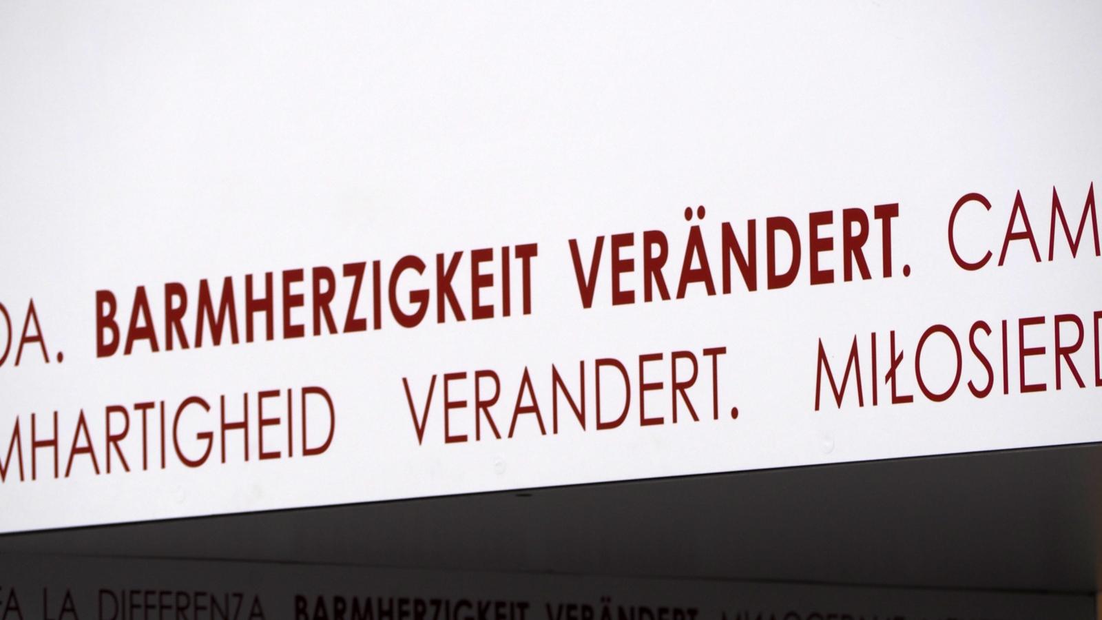 Das Tor der Barmherzigkeit ist Teil der Fasten- und Osterzeit 2016 am Bonner Münster, die unter dem Motto „Barmherzigkeit verändert“ steht.  Dieses Motto ist an den Torseiten und im Innenbereich des Tors umlaufend in elf verschiedenen Sprachen angebracht.  Es begleitet die Menschen, während sie das Tor durchschreiten.  Barmherzigkeit verändert Ex-Bild-DB-ID: 18608