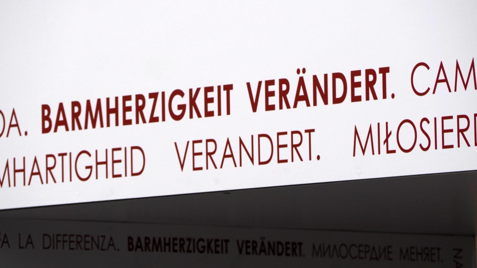 Das Tor der Barmherzigkeit ist Teil der Fasten- und Osterzeit 2016 am Bonner Münster, die unter dem Motto „Barmherzigkeit verändert“ steht.  Dieses Motto ist an den Torseiten und im Innenbereich des Tors umlaufend in elf verschiedenen Sprachen angebracht.  Es begleitet die Menschen, während sie das Tor durchschreiten.  Barmherzigkeit verändert Ex-Bild-DB-ID: 18608