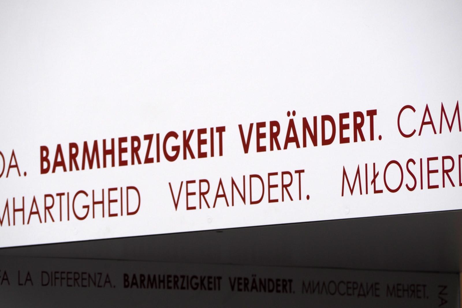 Das Tor der Barmherzigkeit ist Teil der Fasten- und Osterzeit 2016 am Bonner Münster, die unter dem Motto „Barmherzigkeit verändert“ steht.  Dieses Motto ist an den Torseiten und im Innenbereich des Tors umlaufend in elf verschiedenen Sprachen angebracht.  Es begleitet die Menschen, während sie das Tor durchschreiten.  Barmherzigkeit verändert Ex-Bild-DB-ID: 18608