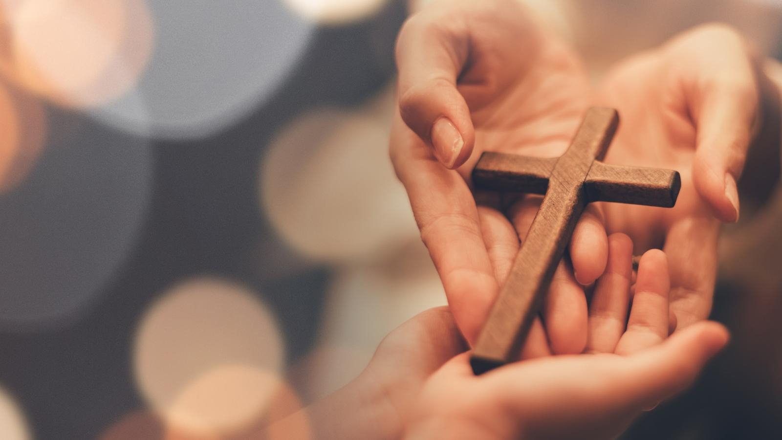 Woman's hand with cross .Concept of hope, faith, christianity, religion, church online.