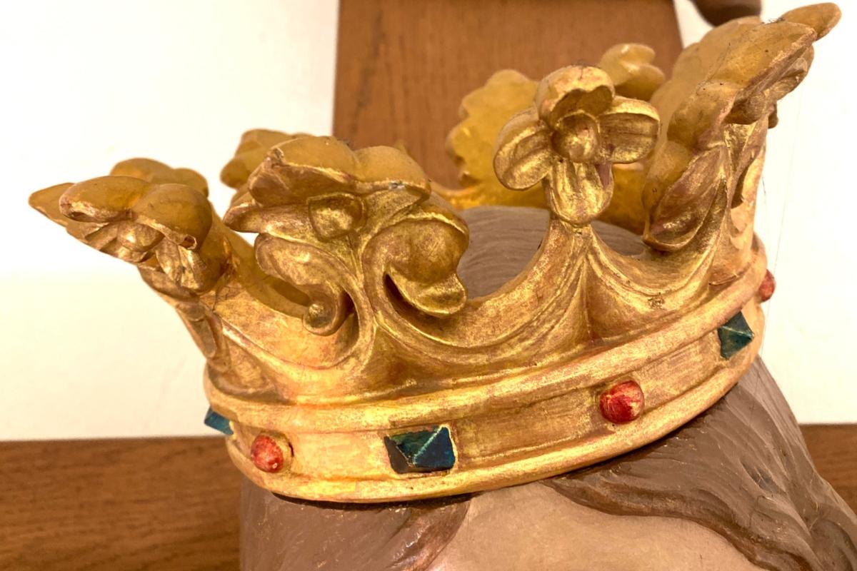 Fotografie einer goldenen Krone auf einer Jesus-Figur am Kreuz.