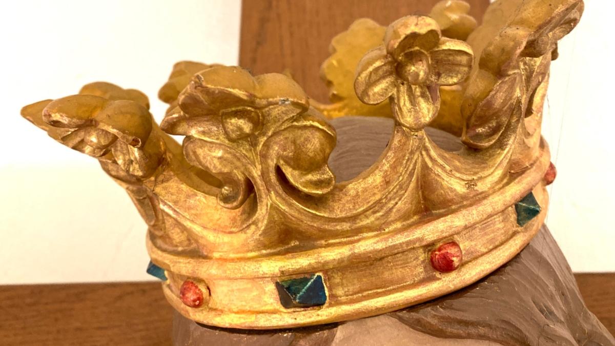 Fotografie einer goldenen Krone auf einer Jesus-Figur am Kreuz.