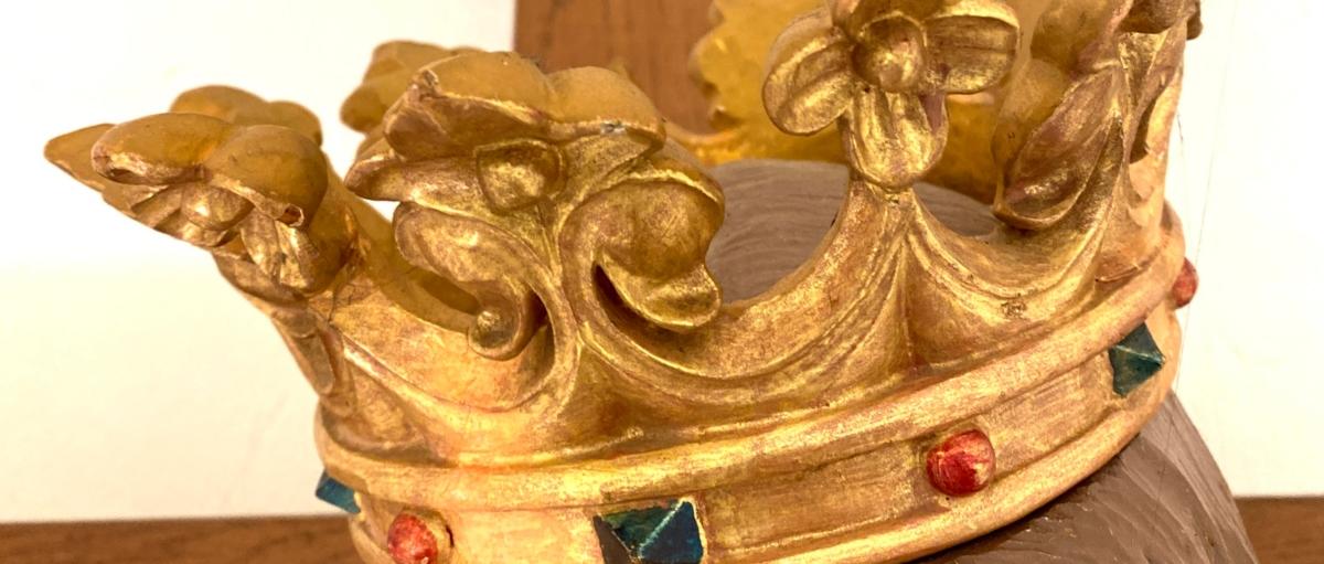 Fotografie einer goldenen Krone auf einer Jesus-Figur am Kreuz.