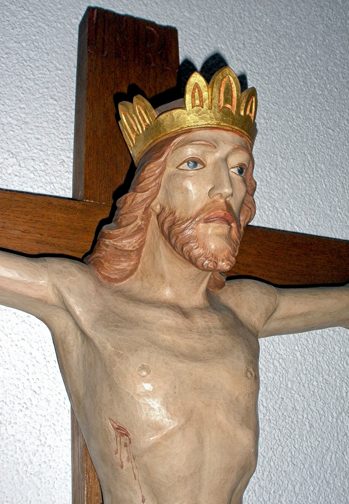 Fotografie einer Jesus-Figur am Kreuz, die eine goldenen Krone trägt.