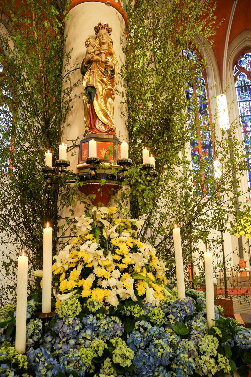 Mit Blumen und Birkenzweigen geschmückter Maialtar in der Sankt Barbara Kirche in Bonn-Ippendorf.