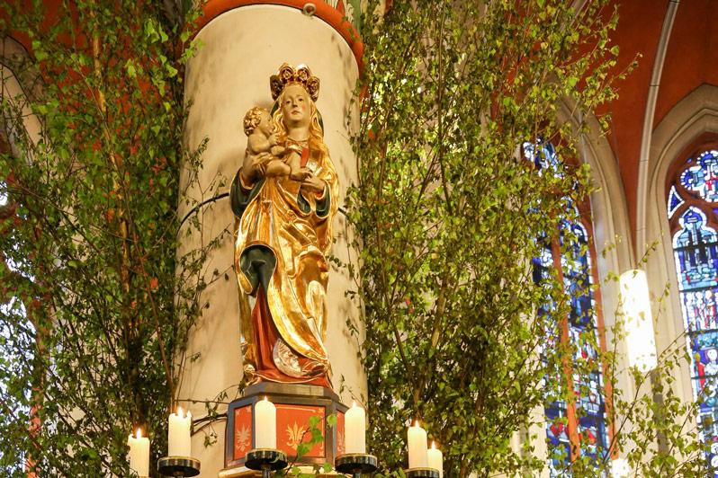 Mit Blumen und Birkenzweigen geschmückter Maialtar in der Sankt Barbara Kirche in Bonn-Ippendorf.