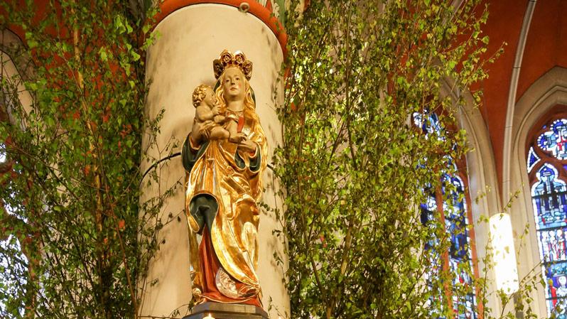 Mit Blumen und Birkenzweigen geschmückter Maialtar in der Sankt Barbara Kirche in Bonn-Ippendorf.