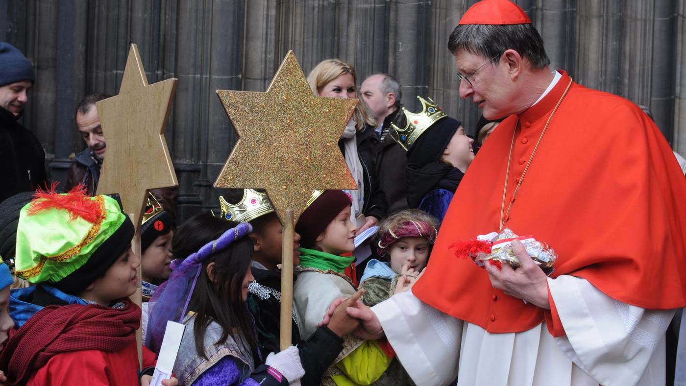 Kardinal Woelki schüttelt den jungen Königen die Hand.