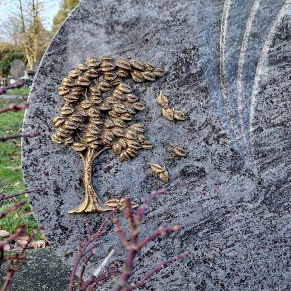 Bild von einem Grabstein auf dem ein Baummotiv ist