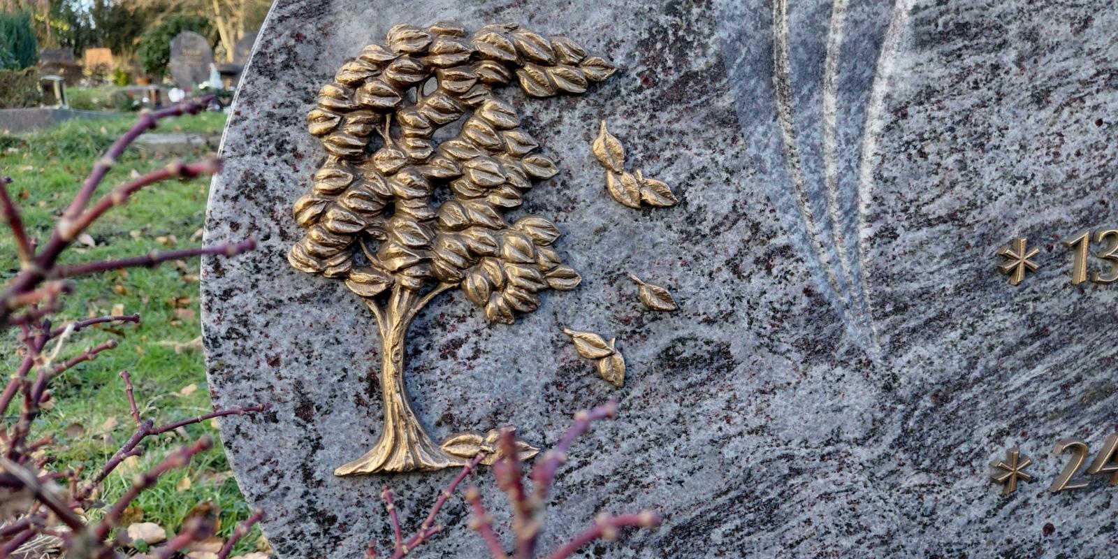 Bild von einem Grabstein auf dem ein Baummotiv ist