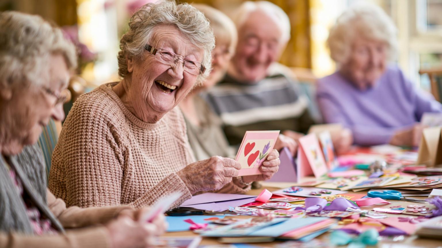 Seniorinnen und Senioren lachend beim Basteln
