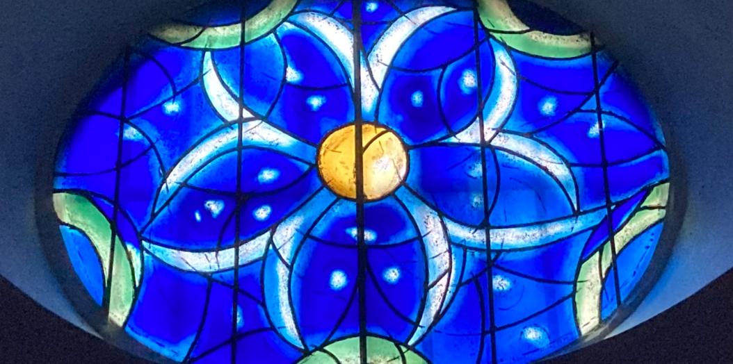 Das Bild zeigt ein blaues Kirchenfenster aus der Kirche St. Stephan