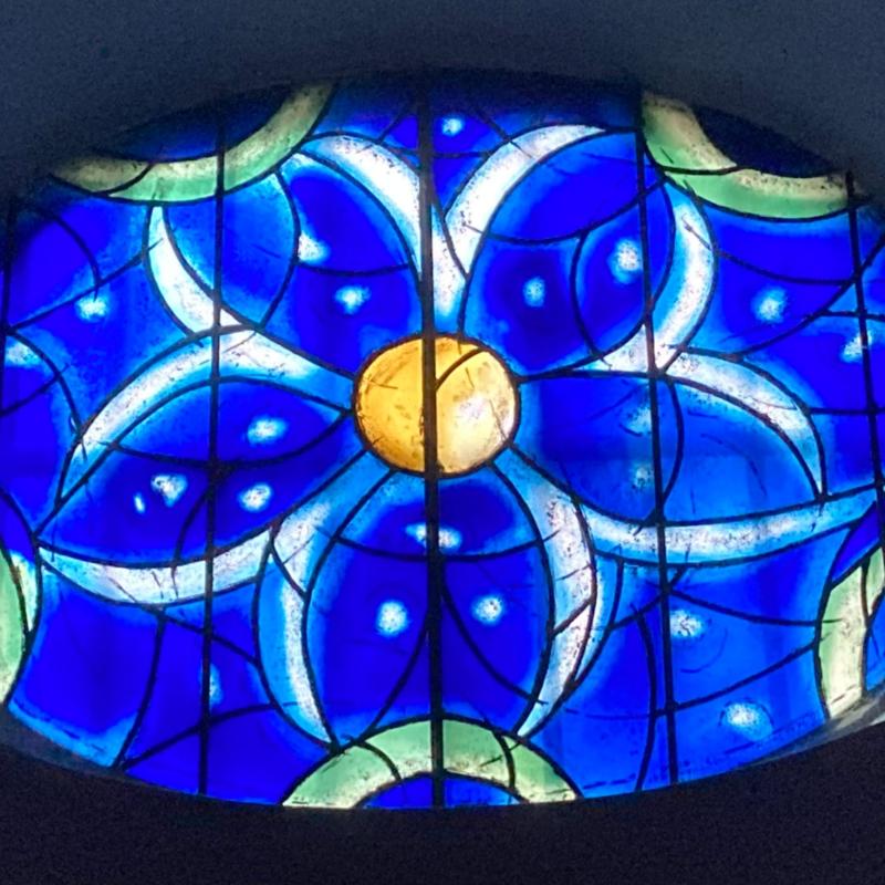 Das Bild zeigt ein blaues Kirchenfenster aus der Kirche St. Stephan