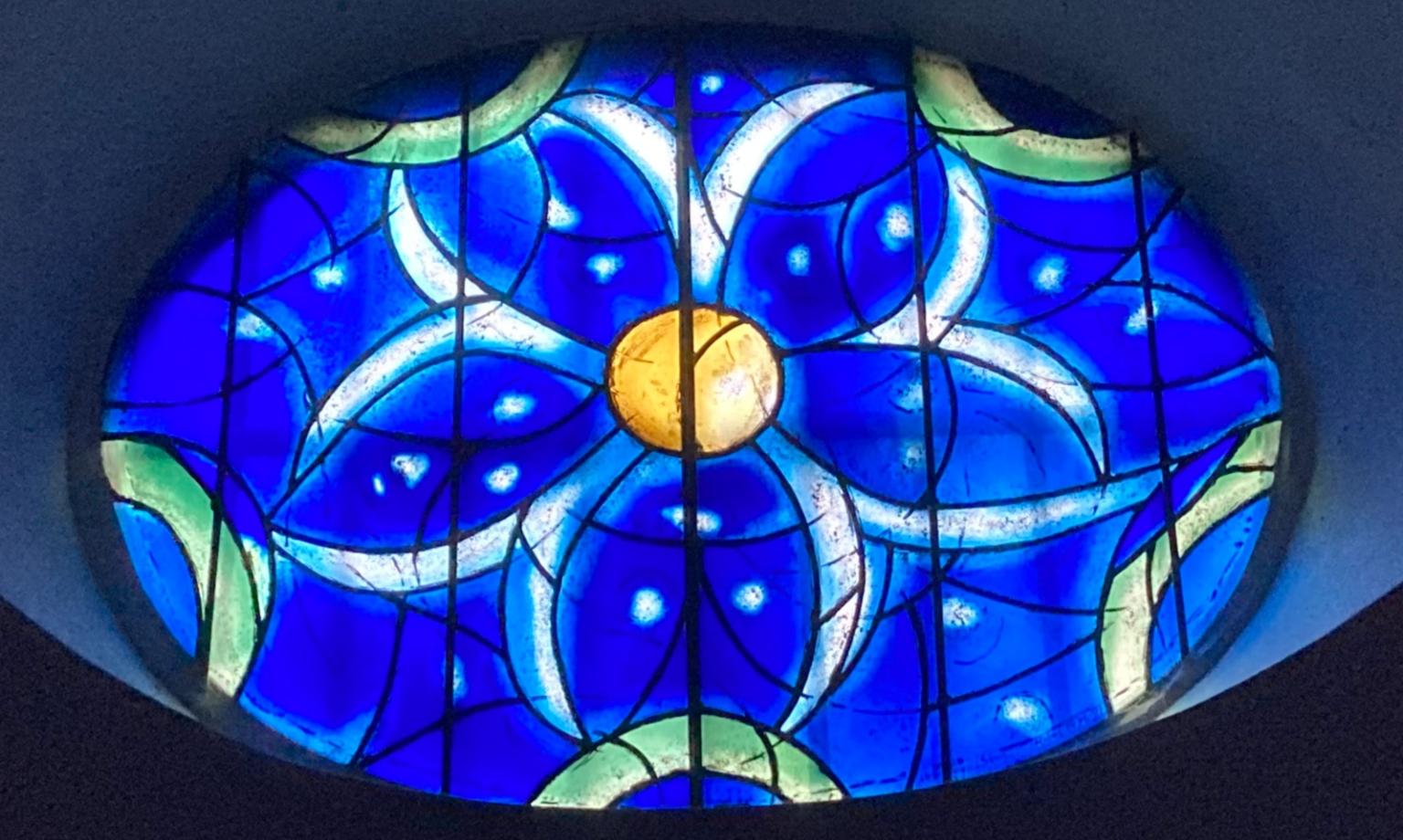 Das Bild zeigt ein blaues Kirchenfenster aus der Kirche St. Stephan
