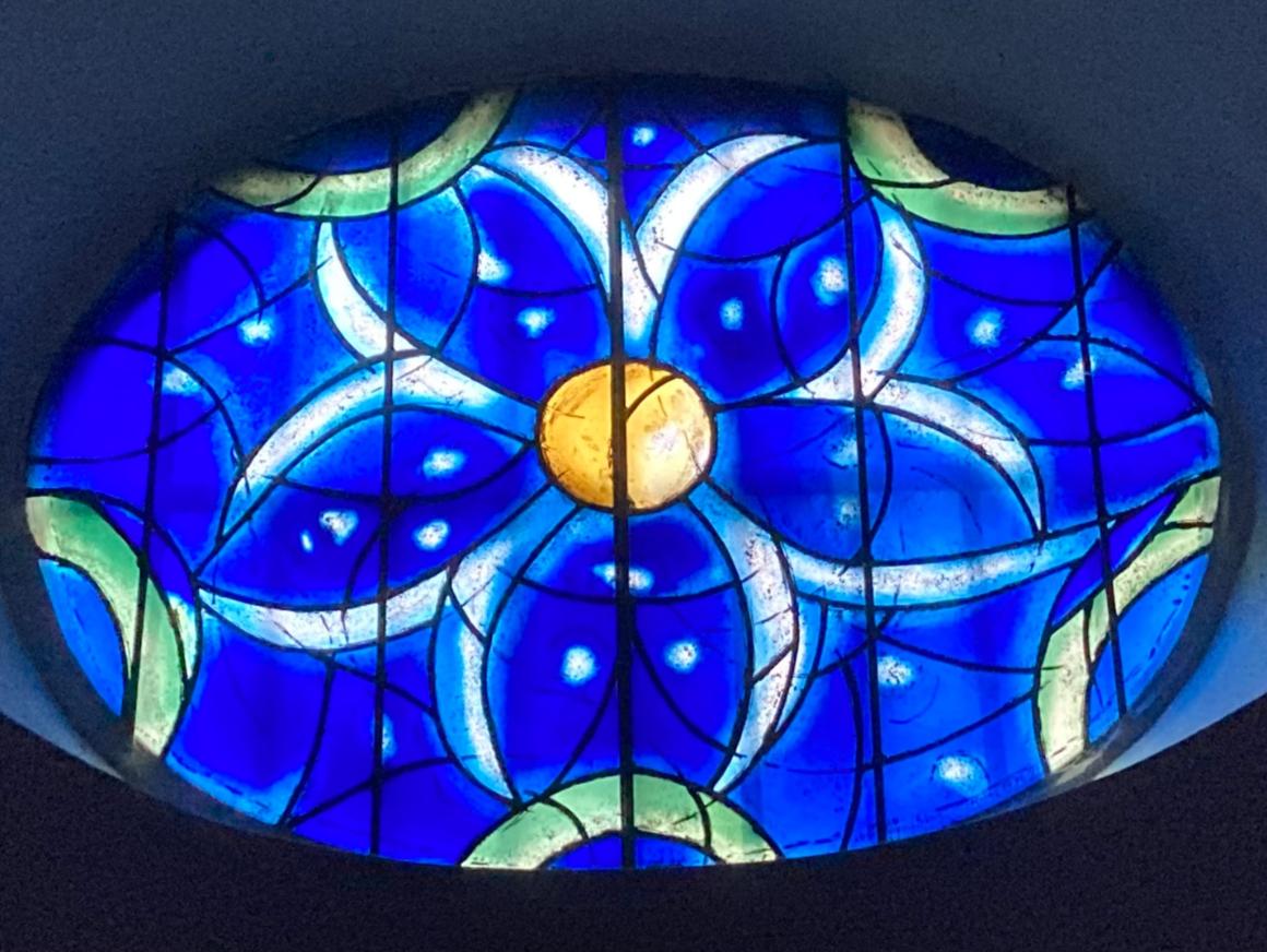 Das Bild zeigt ein blaues Kirchenfenster aus der Kirche St. Stephan