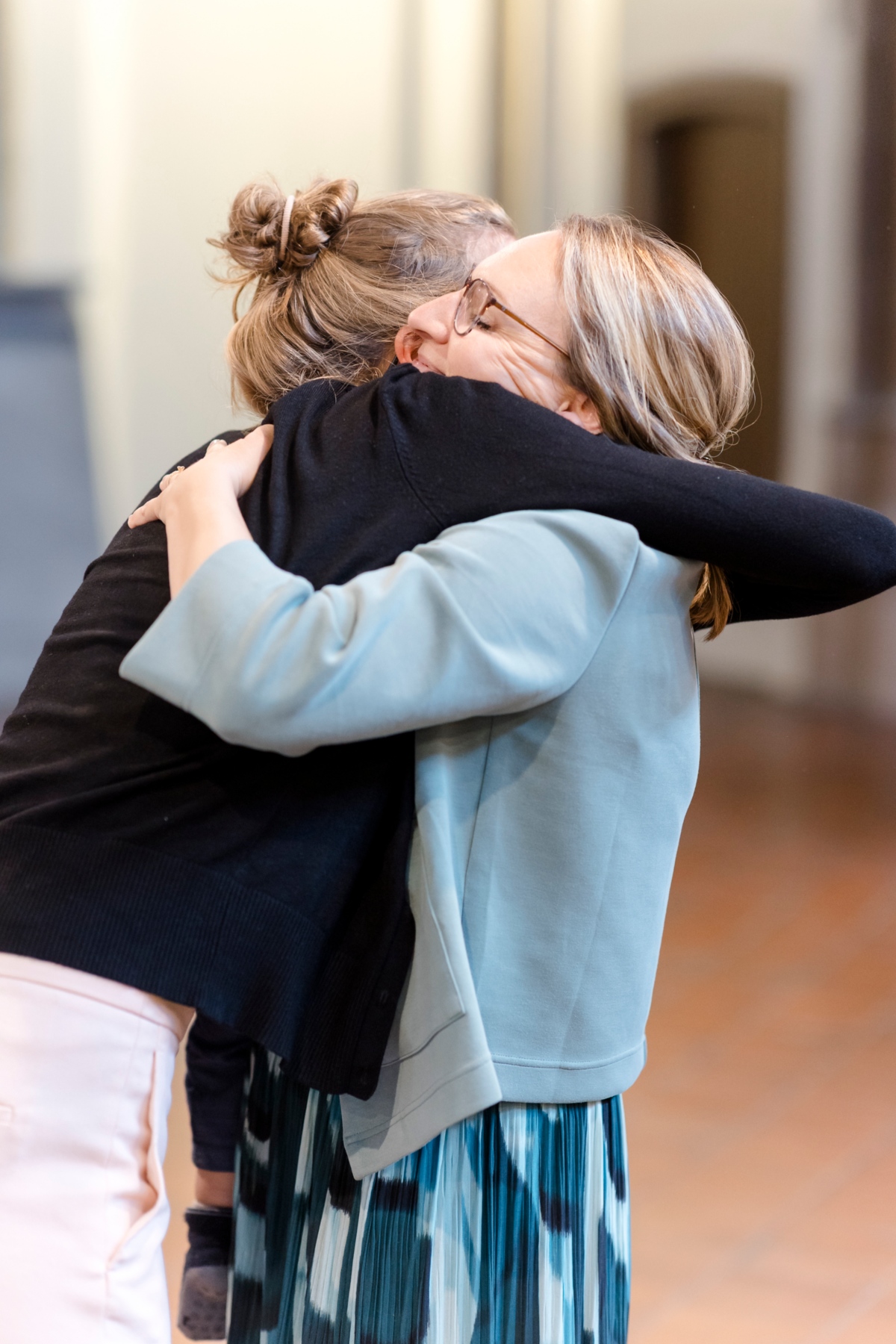 Zwei Personen umarmen sich in der Kirche.