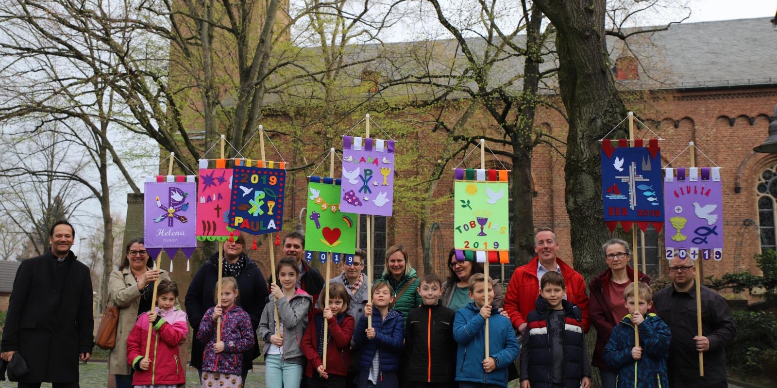 Mit den fertigen Bannern ziehen die Kinder in den Sonntagsgottesdienst ein.