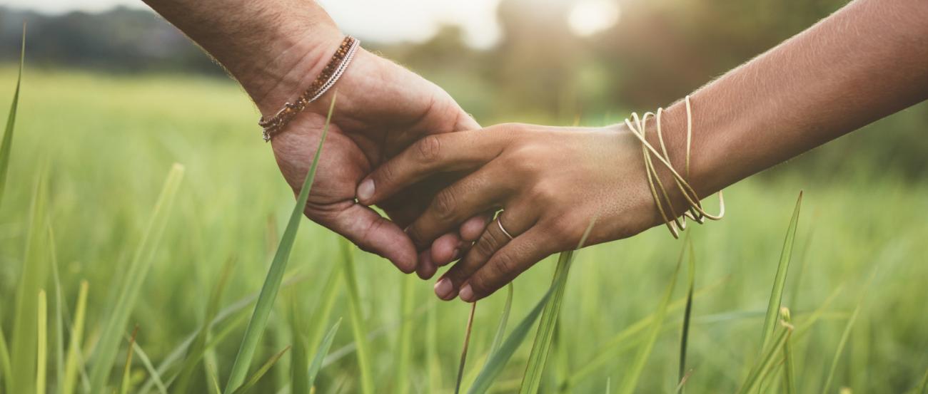 Romantic couple holding hands in a field