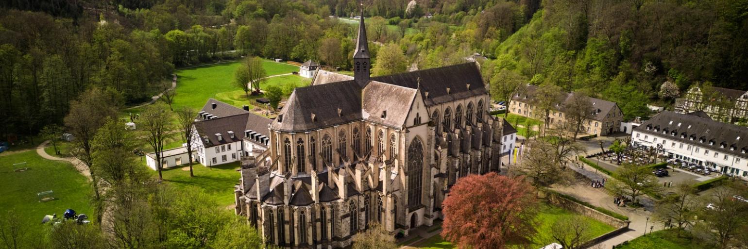 Ein Foto zeigt den Blick von oben auf den Altenberger Dom und Nebengebäude.
