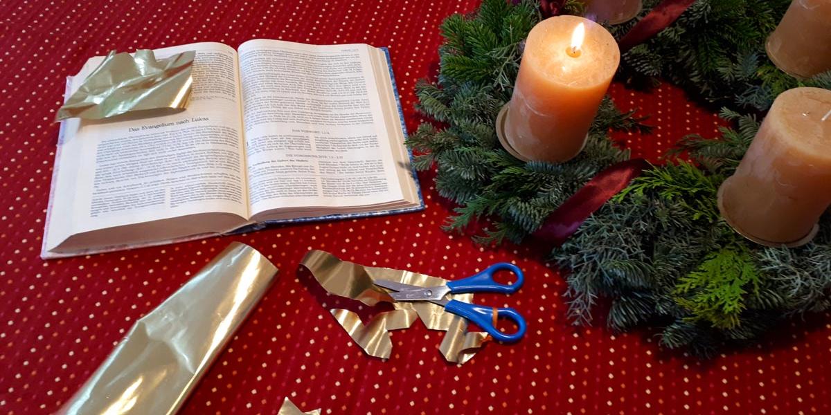 Adventtisch mit Kranz, Bibel, Schere und Goldpapier