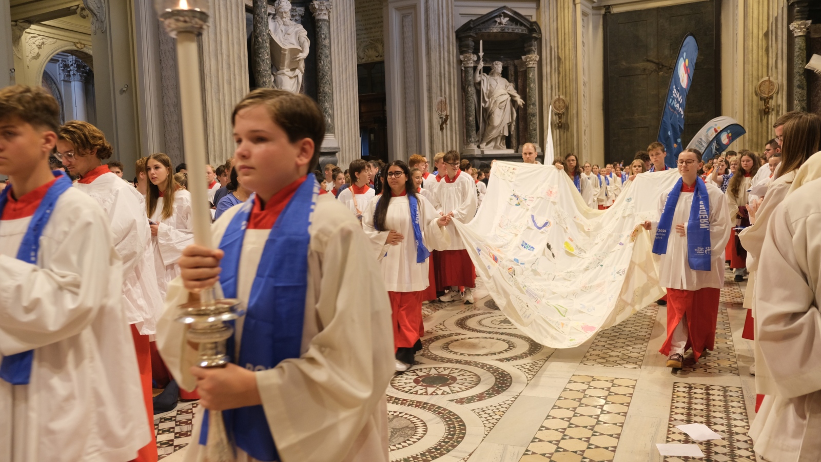 Ministranten setzen ein Segel während des Einzugs in den Gottesdienst